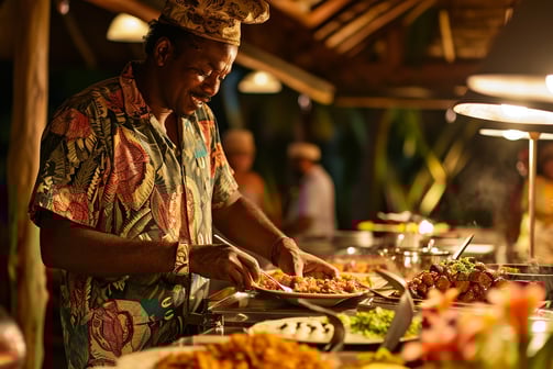 A male resort guest happily filling his plate with traditional Fijian dishes from a buffet table.